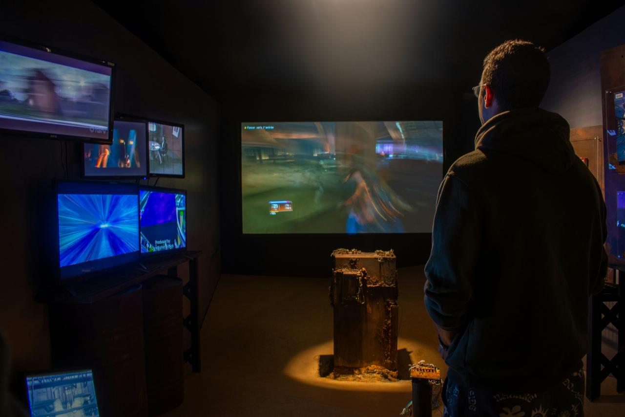A man watches video games on multiple screens.