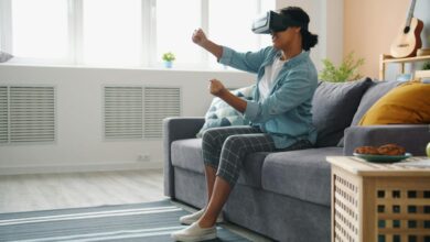 Woman wearing vr headset playing game on couch