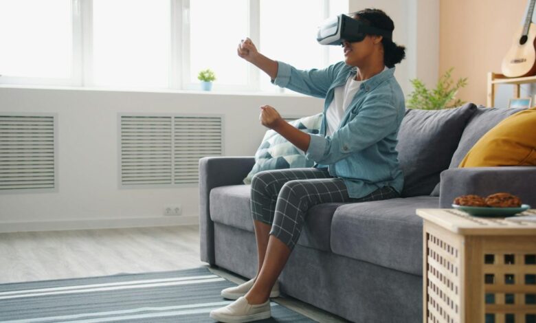 Woman wearing vr headset playing game on couch